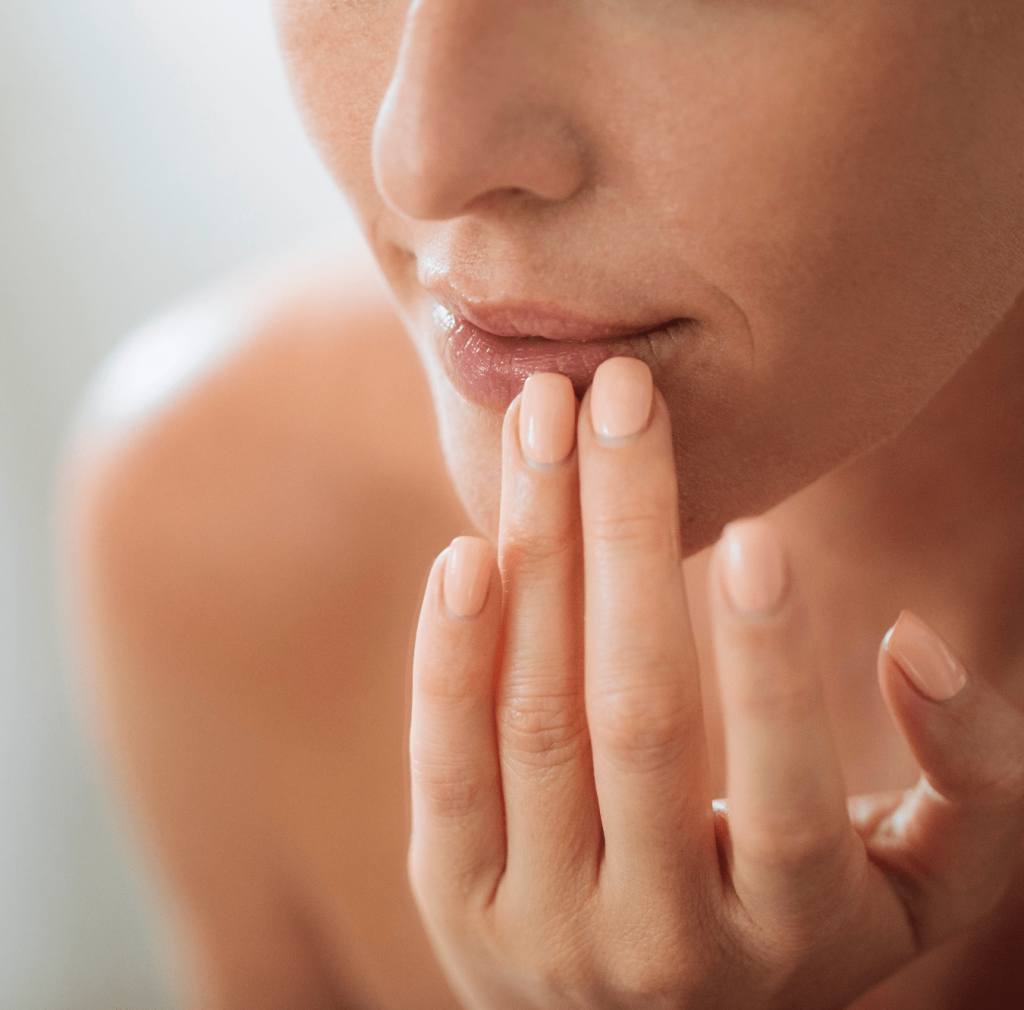 Woman touching her lips with her fingertips