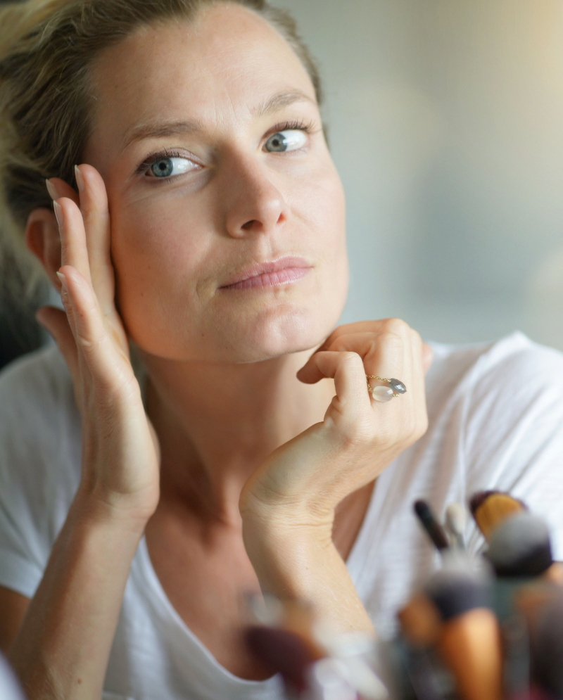 Woman checking her face in a mirror