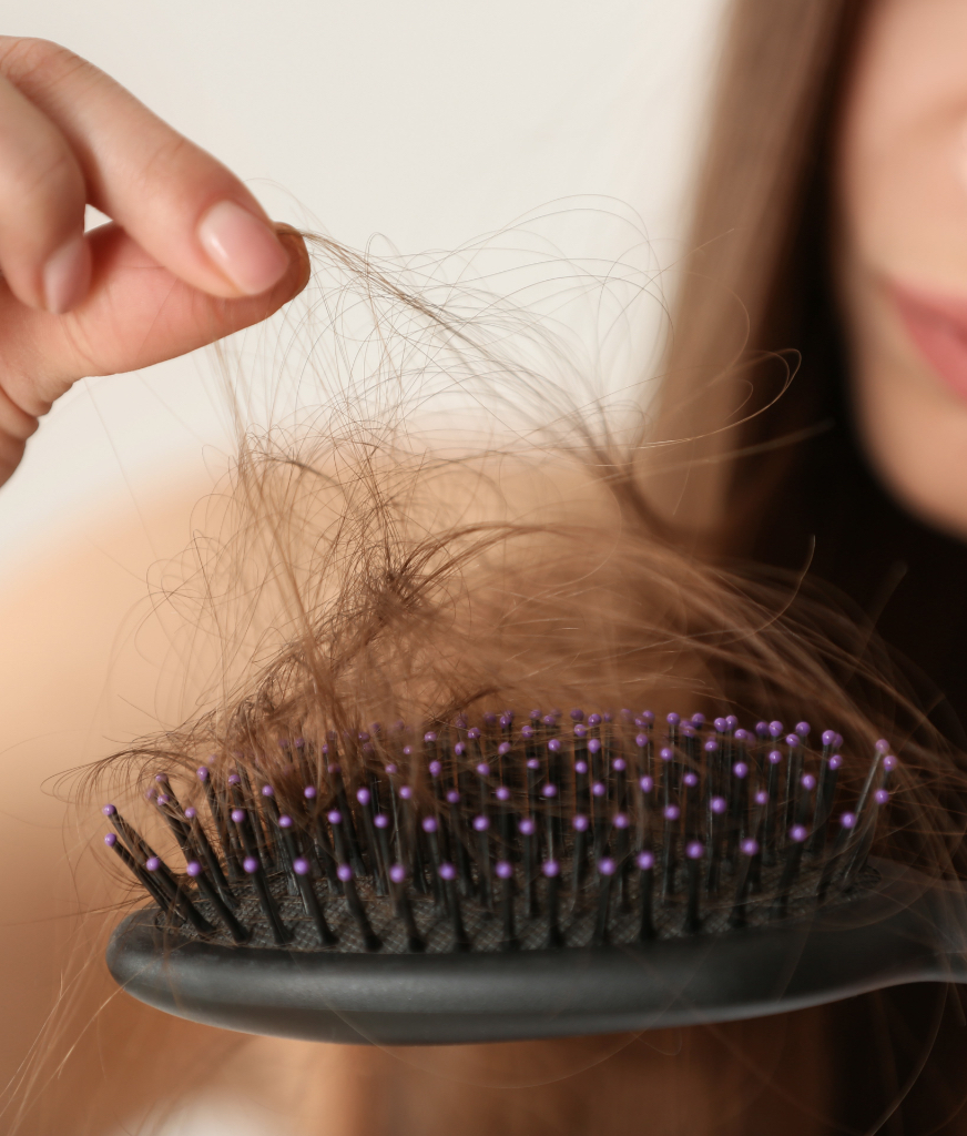 Woman pulling hair from a hairbrush