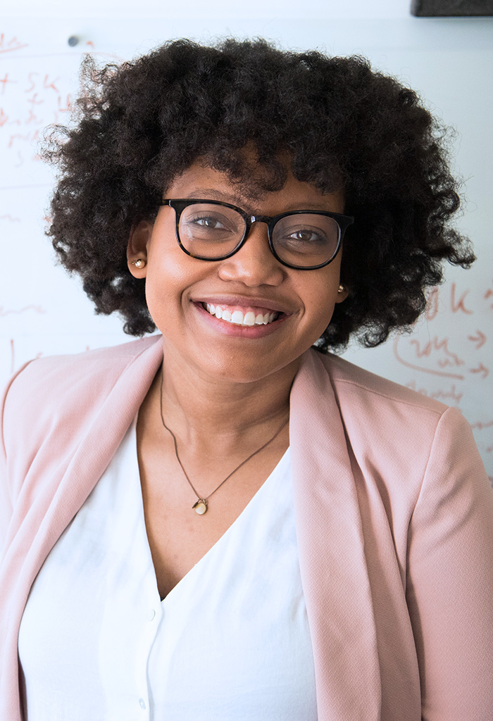 Woman with large black hair and glasses